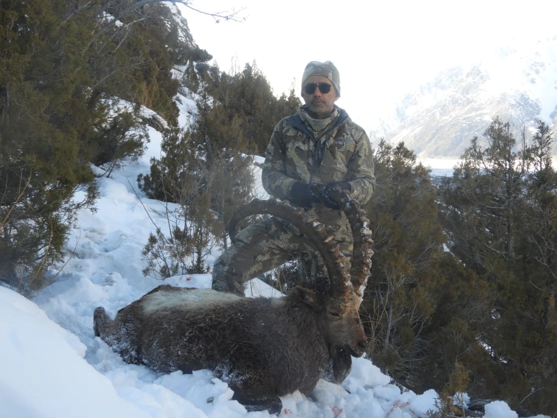 Hunter with recently hunted ibex in higer plains of Hunza Valley around passu glacier.