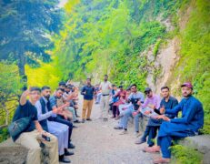 Group of tourists sitting along a scenic forest walking trail in Ayubia giving a thumbs-up pose during a Galyat tour with Pakistan Tour & Travel