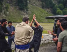 Foreign tourist joining local people in traditional cultural dance on a mountain road in Naran Kaghan