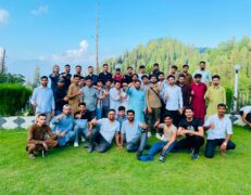 Group of young tourists giving a thumbs-up pose in a hotel lawn garden during a Murree tour package by Pakistan Tour & Travel