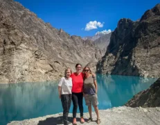 Turquoise Water Edge at Attabad Lake Sightseers standing on the rocky embankment of turquoise Attabad Lake