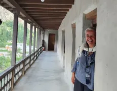 Female Tourist at Baltit Fort Balcony Door Female tourist standing at the wooden balcony doorway of historical Baltit Fort in Karimabad Hunza