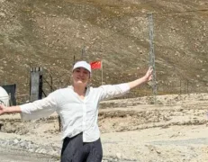 Foreign Tourist at Pak China Border Khunjerab Pass Foreign female tourist standing on the road with arms open wide near the Pak-China border with the Chinese flag in the background