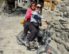Cyclists riding mountain bikes down the hillside village roads of Karimabad