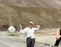Sightseer joyfully waving along the high-altitude Karakoram Highway border post