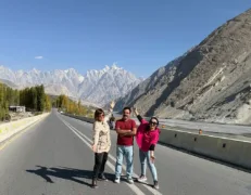 Group taking a casual roadside portrait along the KKH with jagged granite pinnacles behind them