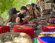 Shoppers browsing handmade crafts and local woolens along the cobblestone street of Karimabad Market