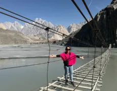 Crossing Hussaini Suspension Bridge Travelers walking across the famous wooden plank Hussaini Suspension Bridge over Hunza River