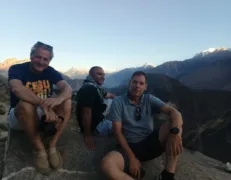 International Guests at Eagles Nest Sunset Point Hunza Three international tourists sitting on a rock during evening at Eagles Nest sunset viewpoint in Duikar Hunza