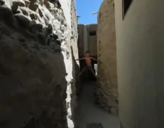 Local Boy in Narrow Alley of Ganish Village Hunza Local boy climbing through a narrow street alley in historic Ganish Village Hunza Valley