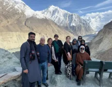Overseas Family and Tour Guide at Hopper Glacier Overseas family posing for a photo with their tour guide at Hopper Glacier viewpoint in Nagar Valley