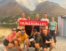 Rakaposhi Mountain Viewpoint Ghulmet Travel group at Ghulmet stop with the snow-covered peak of Rakaposhi rising behind them