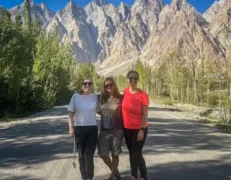 Foreign Female Friends at Passu Cones Viewpoint Three foreign female friends posing on the road with Passu Cones peaks in Hunza Valley