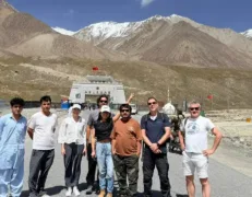 Tourist Group at Khunjerab Pass Border Gate Foreign tourist group posing near the Pak-China border with a female tourist making a peace sign