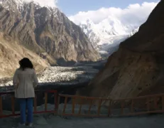 Tourist Admiring Hopper Glacier View in Nagar Valley Overseas female tourist standing at the boundary wall admiring the panoramic view of Hopper Glacier