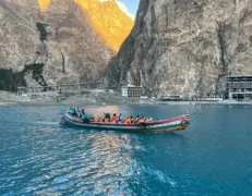 Group enjoying a speed boat ride across turquoise glacier waters framed by rocky cliffs